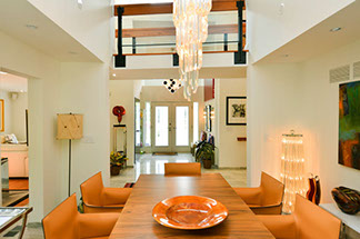 Dining room table with chandelier with balcony above